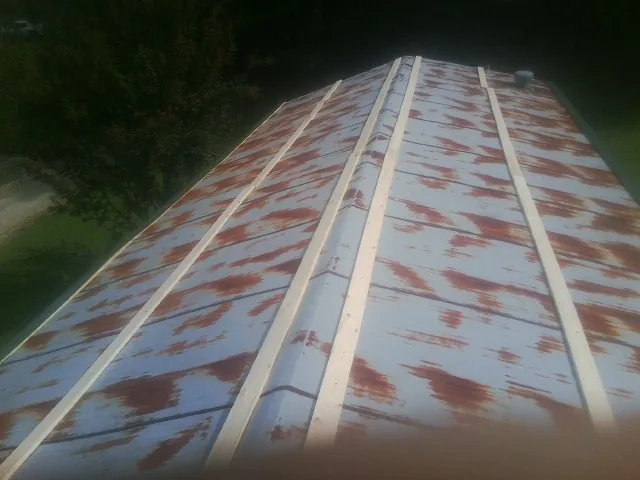 Rusted metal roof panels with new wood purlins before replacement — Storm Damage Roof Repair in Arley by Roofing Brothers