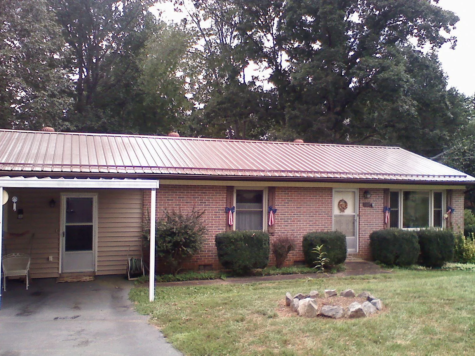 Bronze metal roof and carport on a brick ranch home — Roof Repair work by our crew in Arley